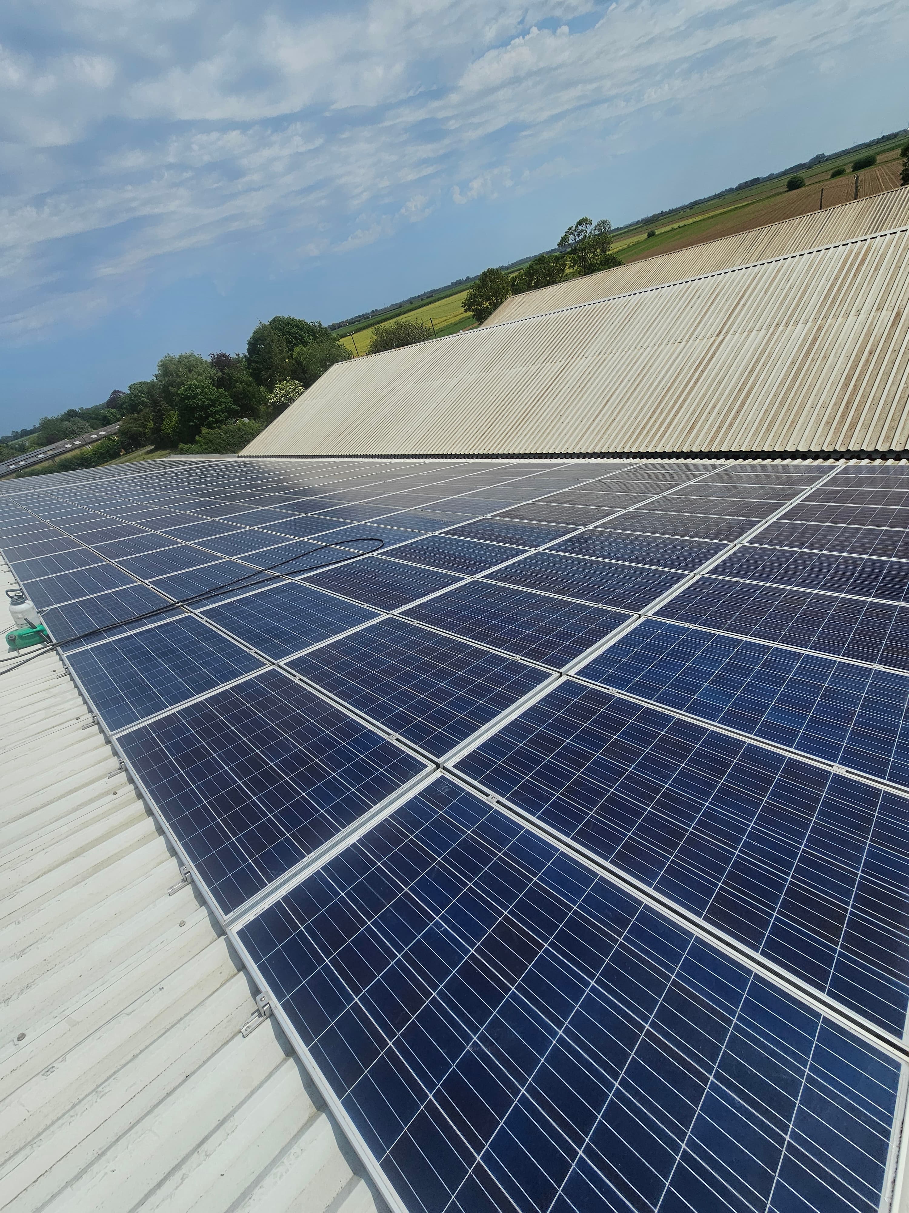 Large solar PV array installed on a white agricultural barn roof in Lincolnshire