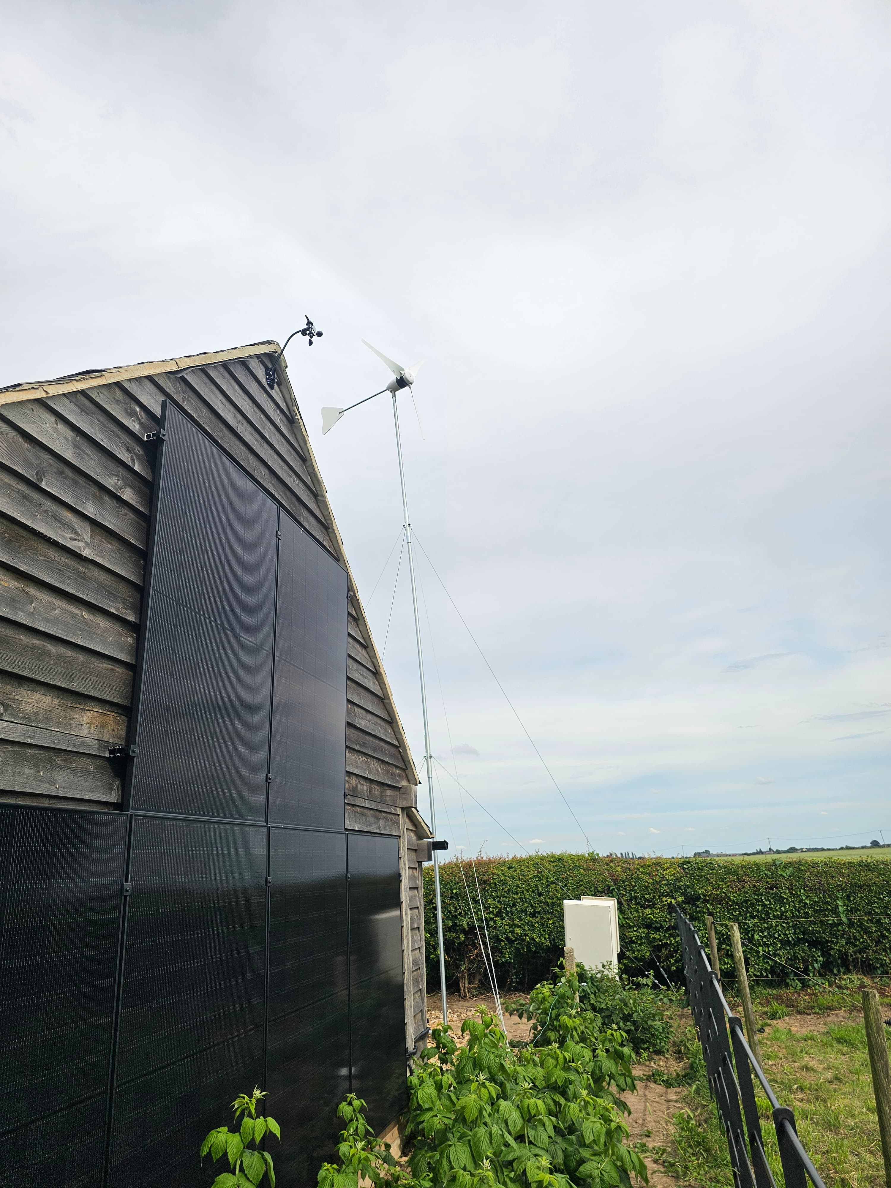 Solar panels installed on a wooden outbuilding roof with countryside views