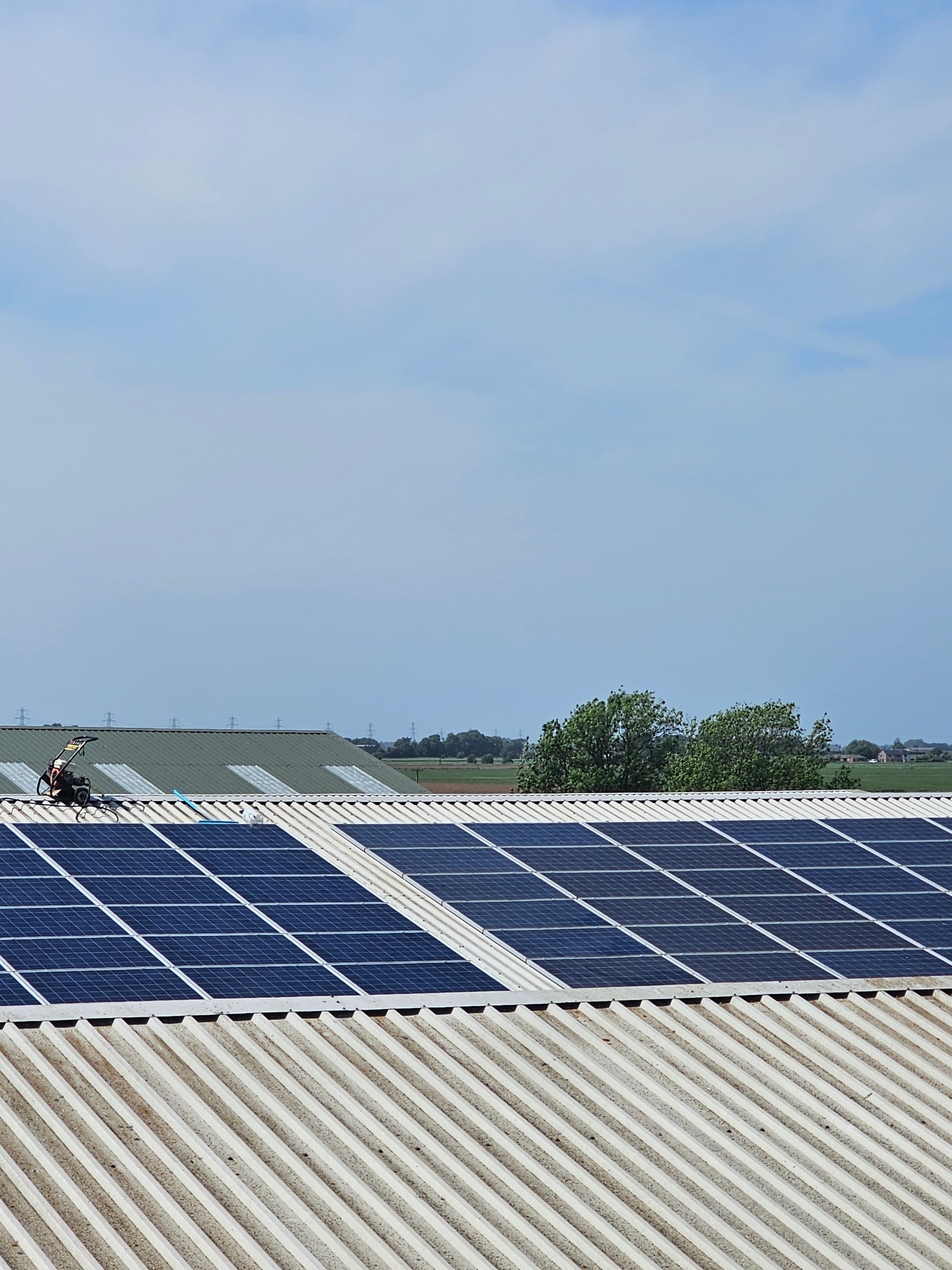 Vertical solar panel installation on a commercial building with technician on aerial lift