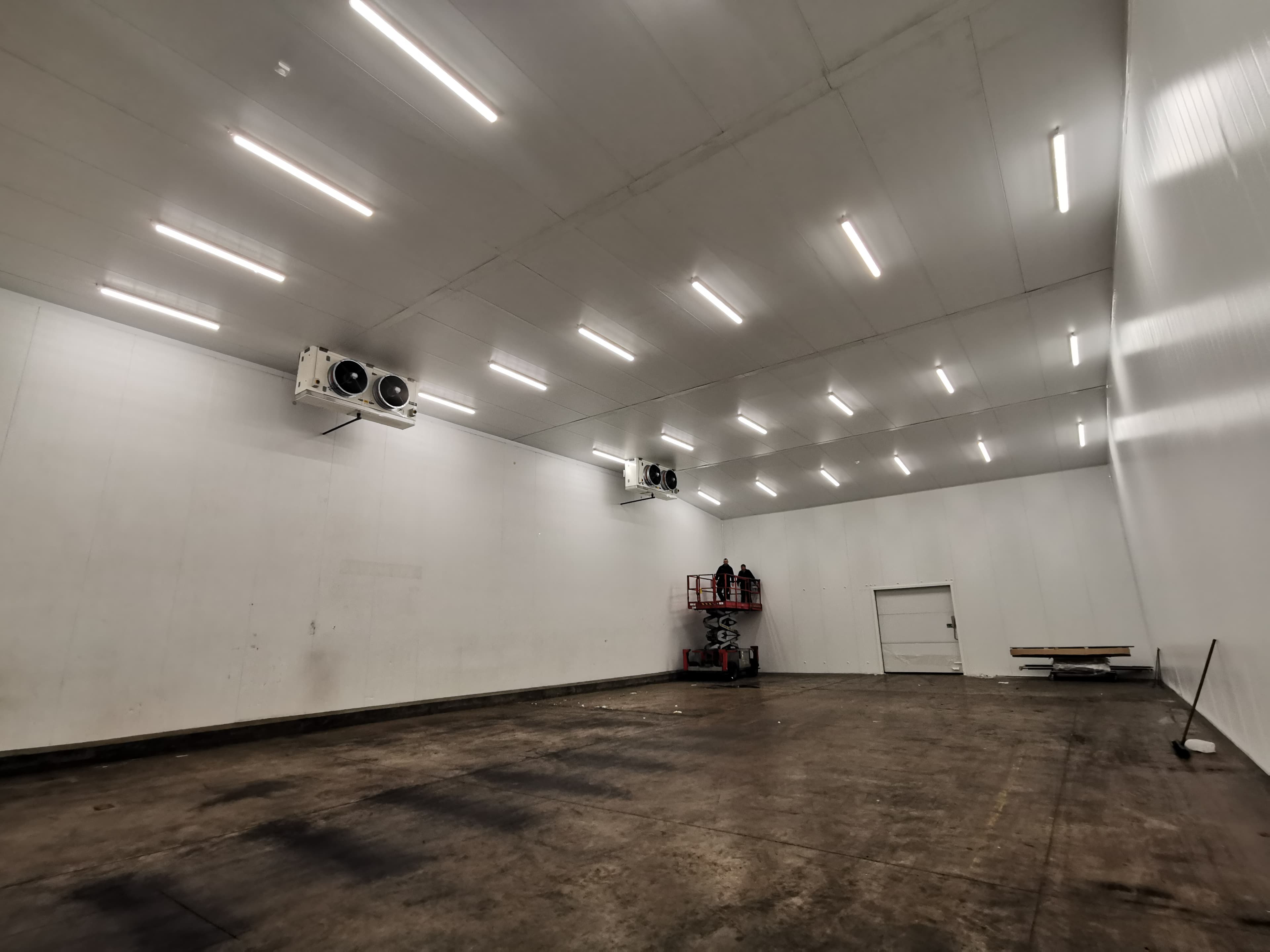 Large cold store interior with refrigeration units being serviced